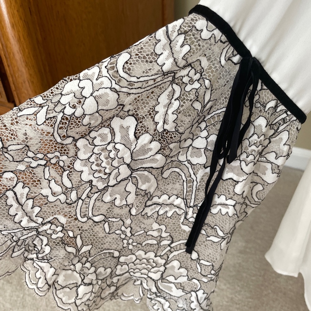 Like New. White House Black market blouse with black trim.